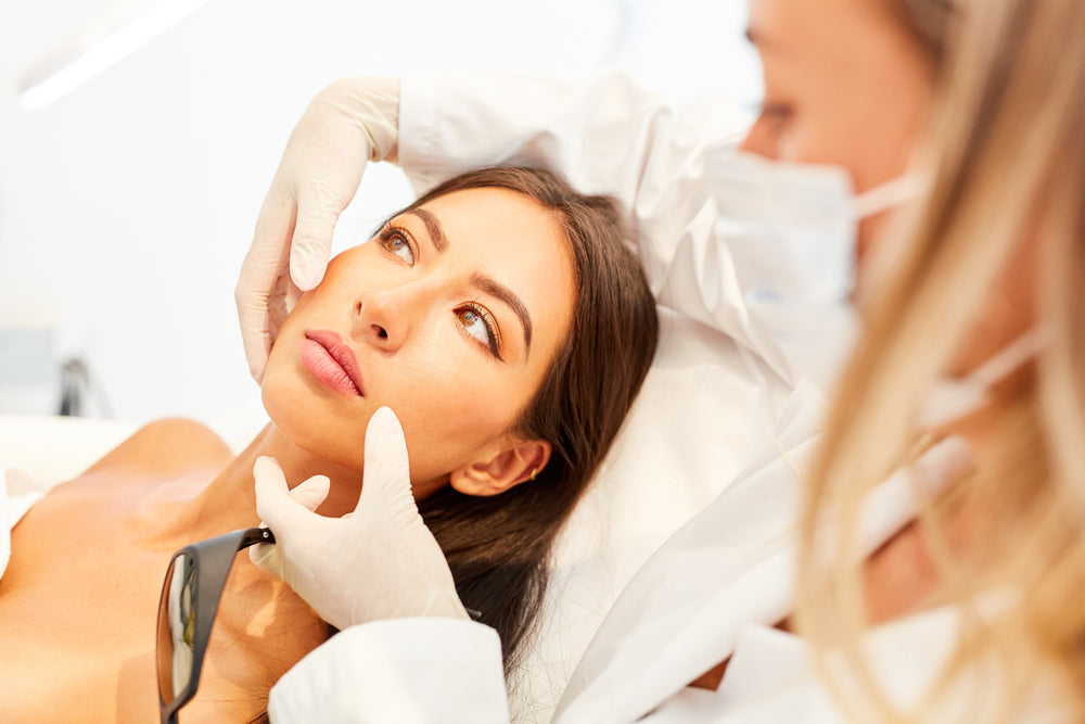 Dermatologist examining a woman’s skin during a consultation