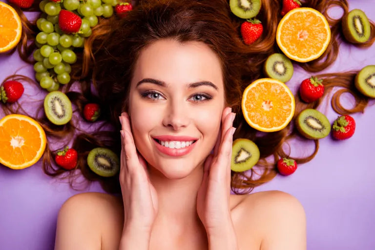 Woman with healthy fruits and vegetables, highlighting foods that nourish skin from within for a radiant glow