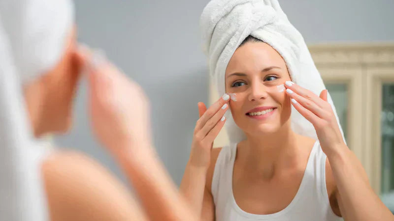 A woman gently applying cleansing cream to her face as part of a skincare routine for combination skin