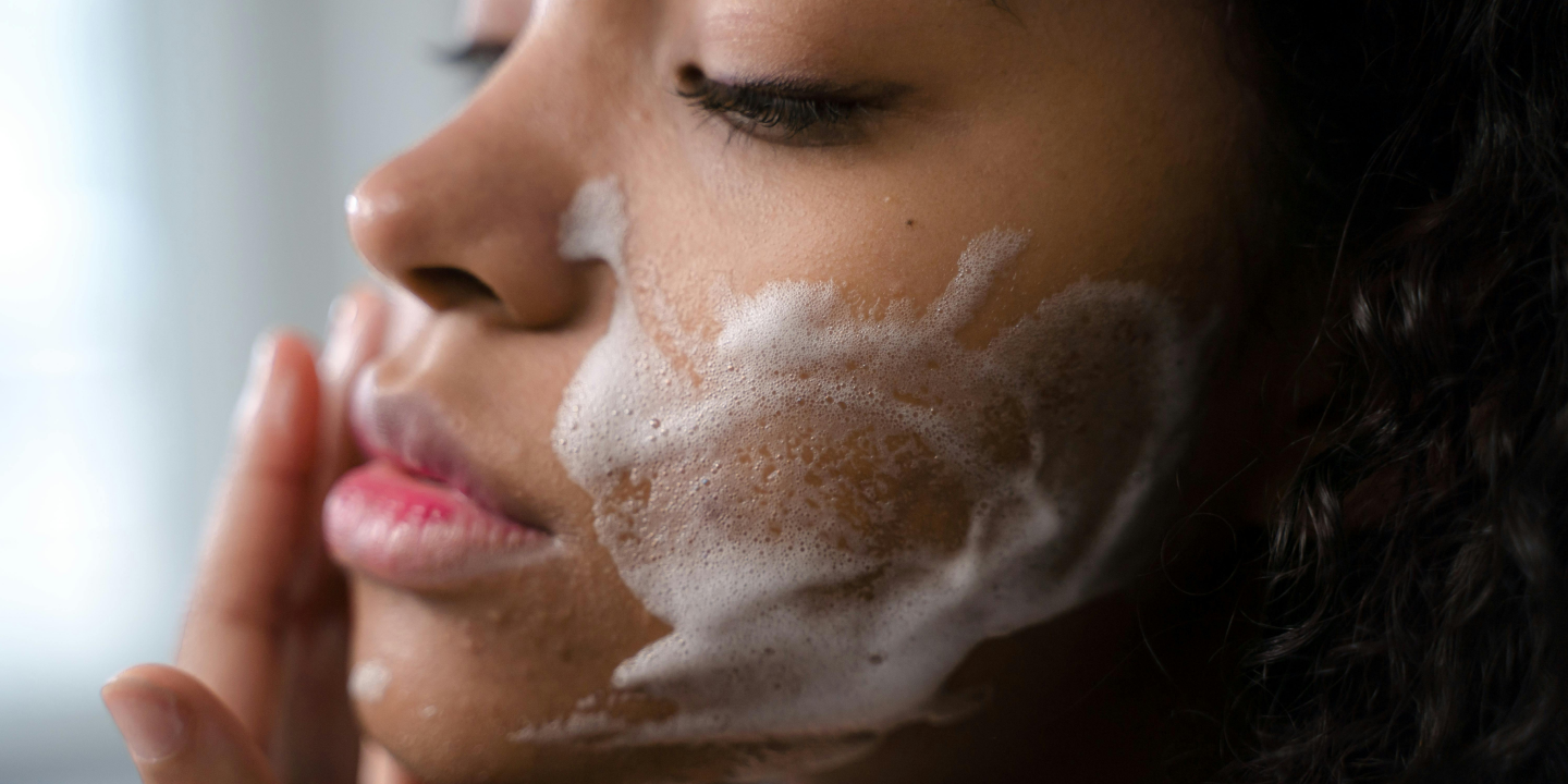 Woman washing her face as part of a clean beauty skincare routine