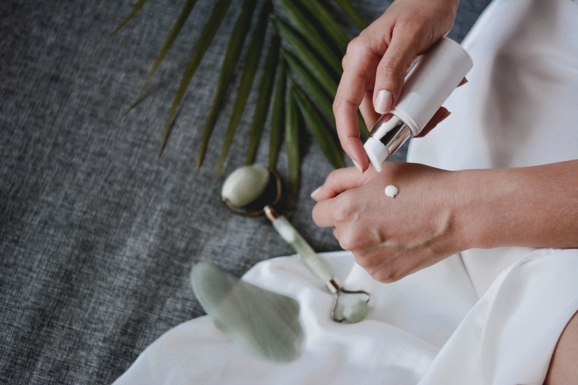 woman pumping a small amount of cream onto the back of her hand