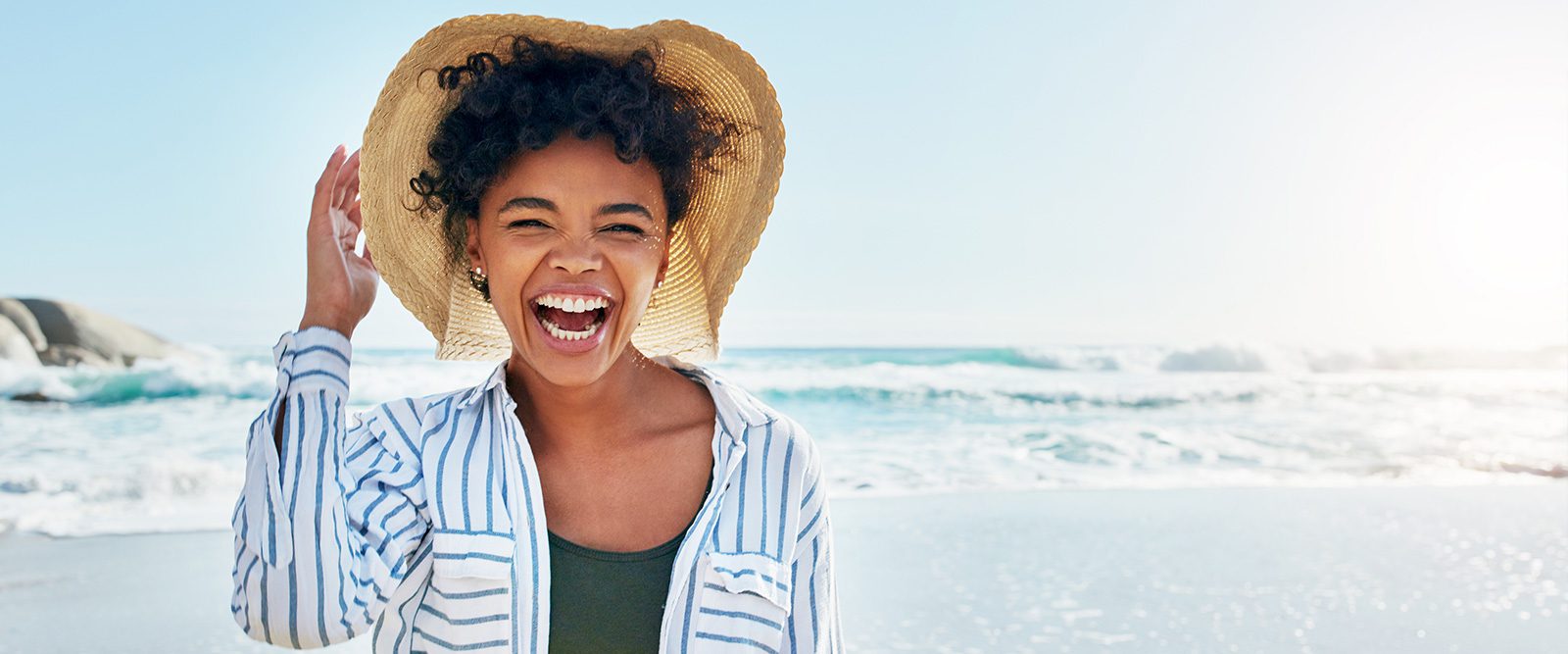 Woman with a hat under sunlight, highlighting it's necessary to prevent sunburn and to protect the skin