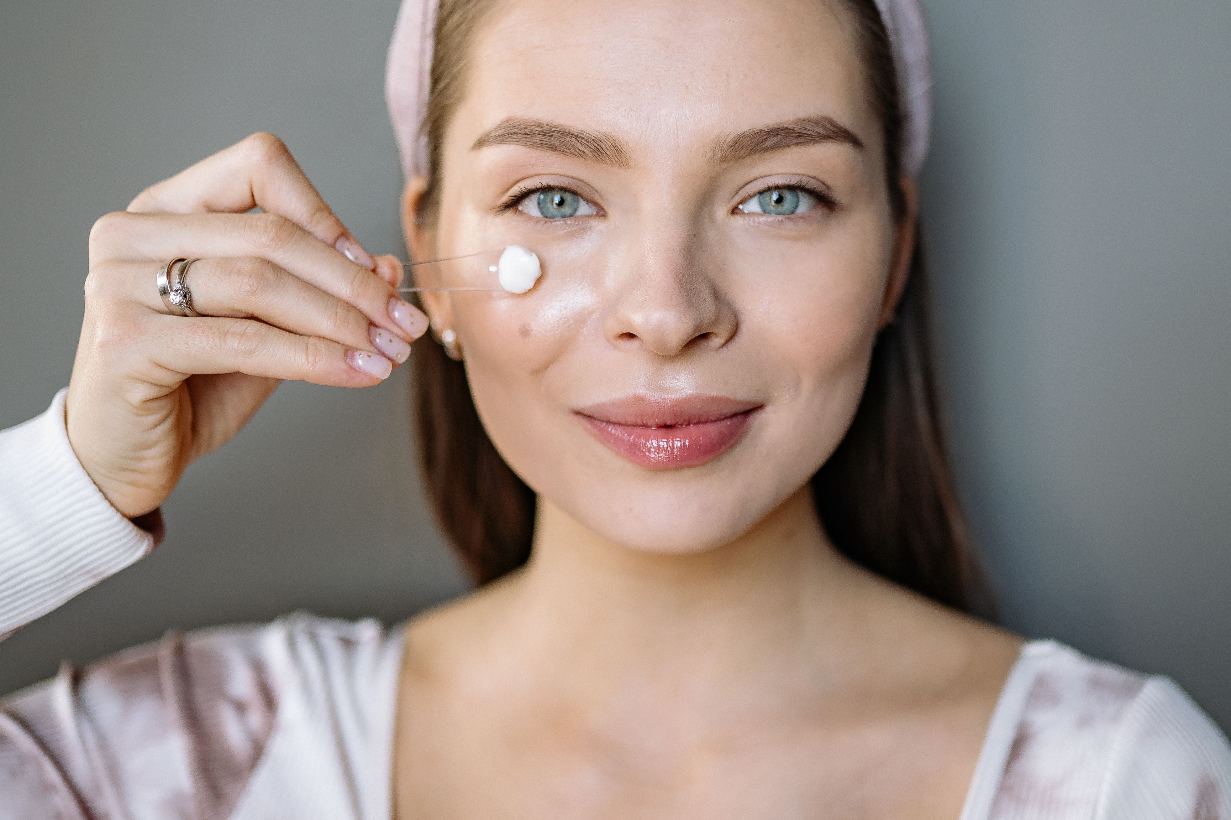 Woman applying facial skincare product