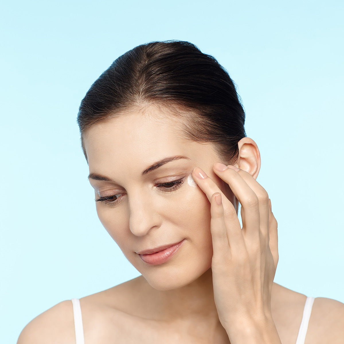 Model applying Restorsea Revitalizing Eye Cream with Vibransea Complex, Front view